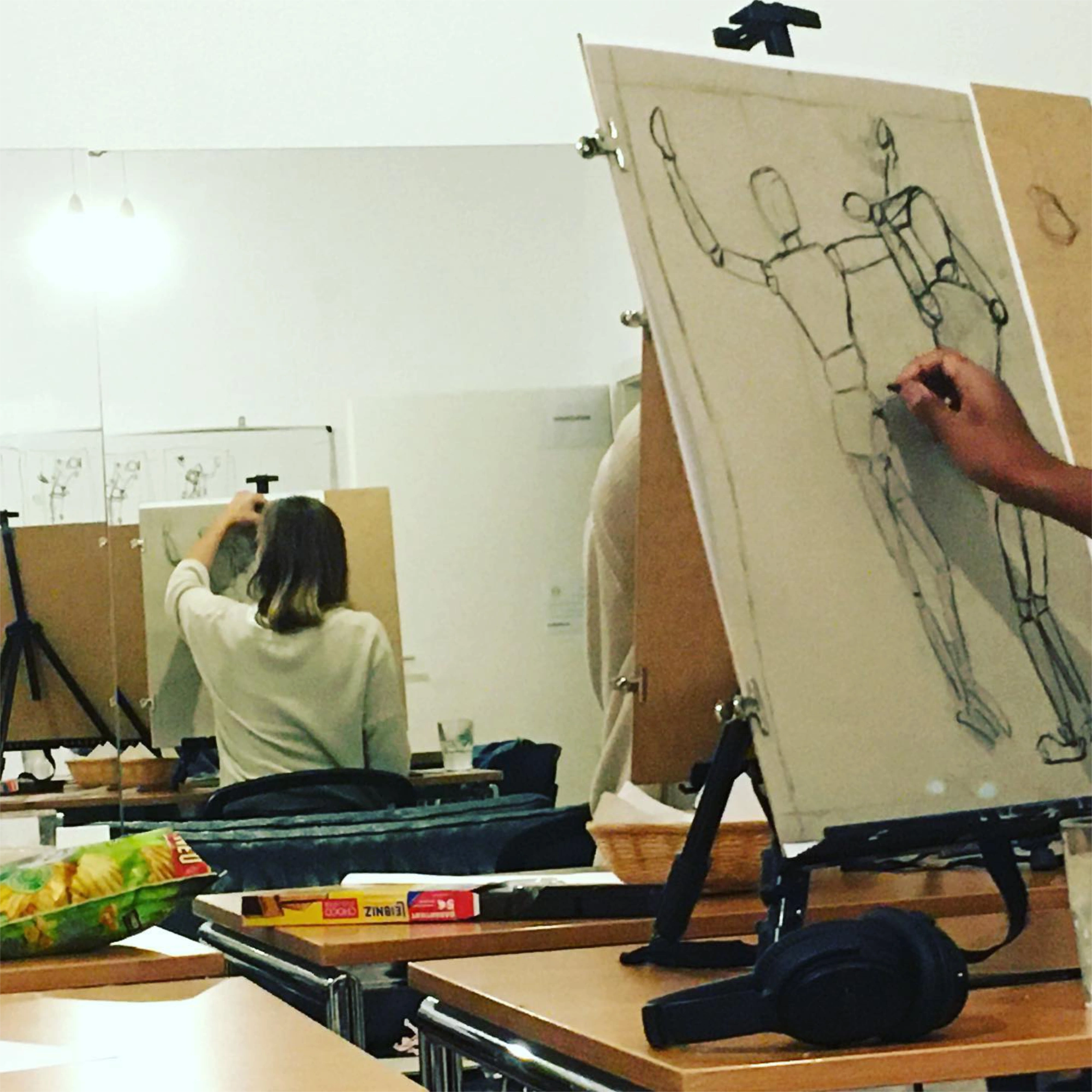 Zeichenteilnehmer arbeiten an Staffeleien im Studio